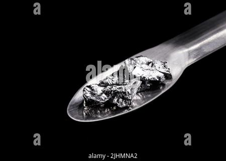 Chromium fragments on trowel, industrial use ore, metallic chemical element, isolated on black background Stock Photo