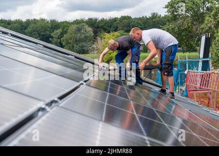 Installation of solar modules on the roof of a barn, a farm, over 240 photovoltaic modules are installed on the roof, NRW, Germany Stock Photo