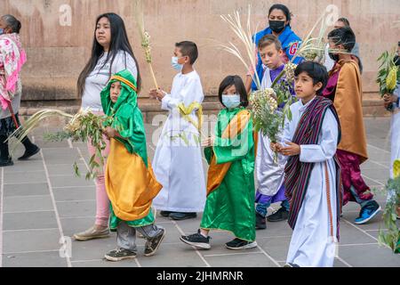 Young Mexican children, dressed in costume, join a Palm Sunday procession at the Basílica de Nuestra Señora de la Salud, or Basilica of Our Lady of Health, in celebration of the traditional Sunday service marking the start of holy week, April 10, 2022 in Patzcuaro, Michoacan, Mexico. Stock Photo