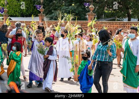 Young Mexican children, dressed in costume, join a Palm Sunday procession at the Basílica de Nuestra Señora de la Salud, or Basilica of Our Lady of Health, in celebration of the traditional Sunday service marking the start of holy week, April 10, 2022 in Patzcuaro, Michoacan, Mexico. Stock Photo