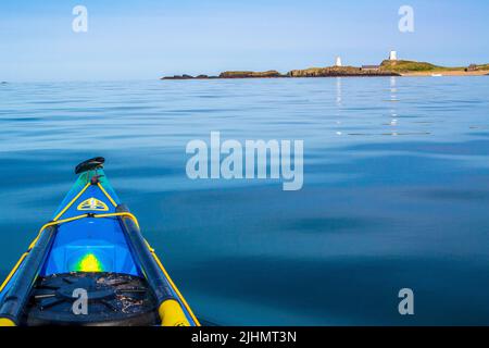 Sea kayaking / canoeing to Llanddwyn Island on the coast of Anglesey, North Wales, UK Stock Photo