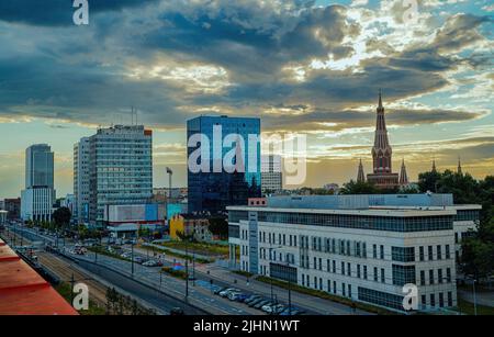 Lodz, Poland - July 08, 2022: Wide angle aerial view of cityscape with mix of modern and medieval architecture next to highway and city tram tracks Stock Photo