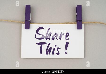 Business and people concept. On a gray background, a business card with the inscription - Share This Stock Photo