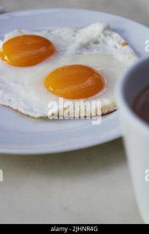 two fried eggs sunny side up, for breakfast time in the morning Stock Photo