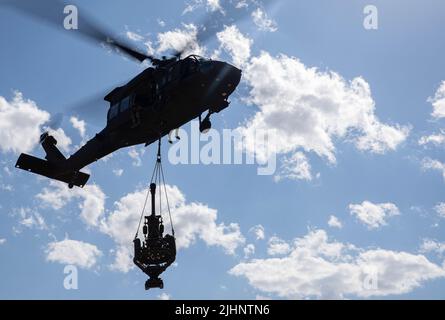 UH-60 Blackhawk Helicopter Pilots assigned to the 3rd Battalion, 227th Aviation Regiment carry a M119A3 Howitzer assigned to Alpha Battery, 1st Battalion, 320th Field Artillery Regiment, 2nd Brigade Combat Team “STRIKE”, 101st Airborne Division (Air Assault) during Elevator Drills as part of Sling Load Operations on July 18, 2022, at Mihail Kogalniceanu, Romania. The Screaming Eagles of today are ready to support our allies in order to preserve the long-lasting stability in Europe that our predecessors fought and died for. (U.S. Army photo by Staff Sgt. Malcolm Cohens-Ashley, 2nd Brigade Comba Stock Photo