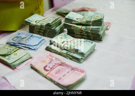 Thai money banknotes tied up on the table Stock Photo