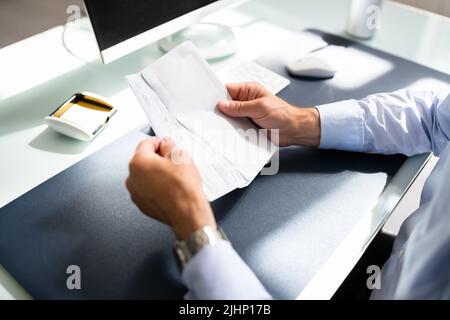 Holding Paycheck Or Payroll Check. Insurance Payment Stock Photo