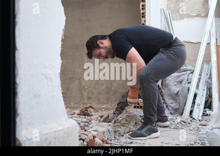 Handyman using a jackhammer to drill into wall. Stock Photo