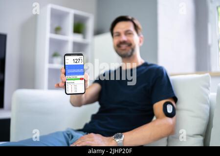 Man Using Continuous Glucose Remote Monitor Diabetes Sensor Stock Photo
