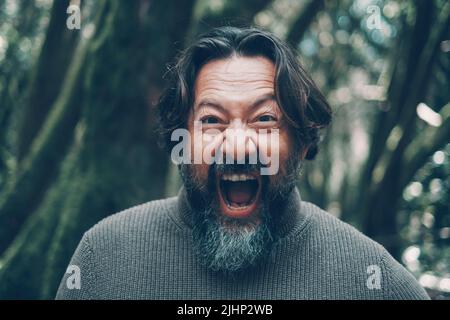 Mad mature man shouting crazy at the camera. Stressed people portrait concept life. Bearded young senior man shout with craziness and open mouth. Emot Stock Photo