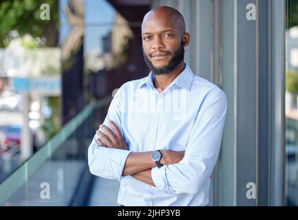 Businessman standing arms crossed in office. Confident businessman standing arms crossed in office. Stock Photo