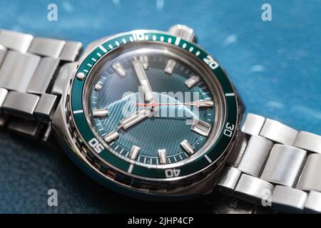 Automatic mechanical diver mans wrist watch with green deal, date indication and rotating ceramic bezel. Closeup photo with selective soft focus Stock Photo