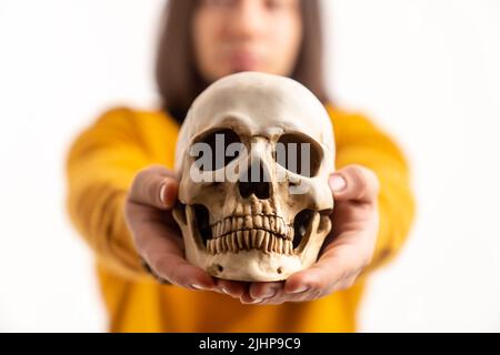 caucasan medical student holding an artificial molder of a human skull - isolated closeup. High quality photo Stock Photo