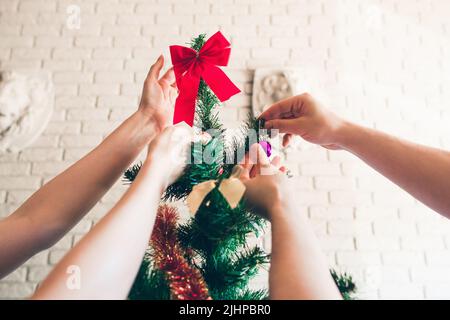 Happy family decorating Christmas tree, close-up Stock Photo