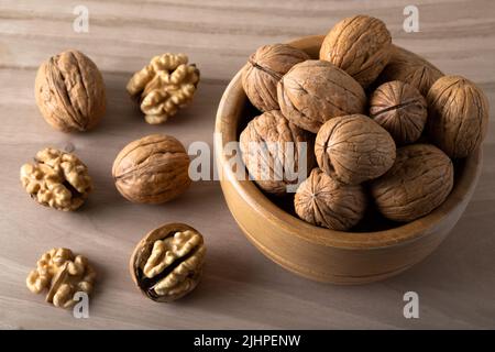 Whole shelled walnuts and cracked walnuts on wooden background Stock Photo