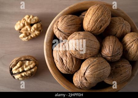 Whole shelled walnuts and cracked walnuts on wooden background Stock Photo