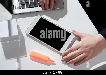 Businesswoman Presenting Important Message On Mobile Phone Screen On Desk With Notes, Marker And Lap Top. Woman Showing Crutial Information On Stock Photo