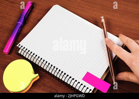 Man Showing Recent Informations On Notebook On Desk With Notes And Pencils. Businessman Presenting Important Message On Notepad On Table With Memos. Stock Photo