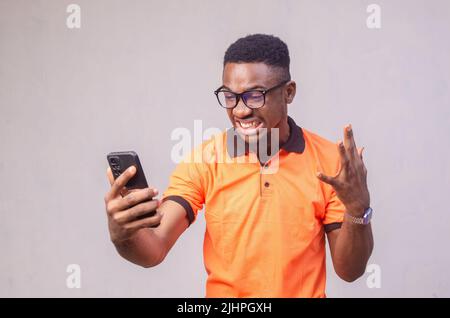 Photo of overjoyed crazy casual brown haired bearded man in eye glasses t-shirt rejoicing in victorious event expressing emotions on face Stock Photo