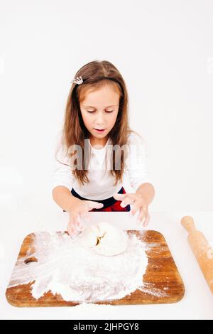 Little girl kneading dough at kitchen Stock Photo