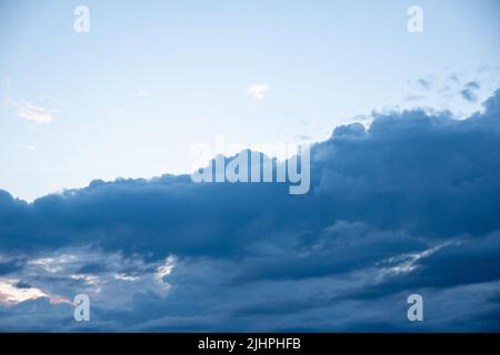 Dark blue evening sky with clouds. Blue hour. Heavenly natural background to overlay on your photos. Stock Photo