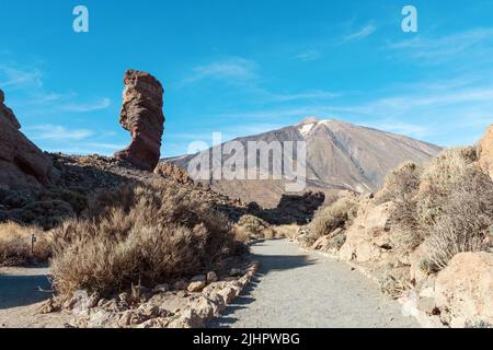 Panoramic view of unique Roque Cinchado unique rock formation with famous Pico del Teide mountain volcano summit in the background on a sunny day, Tei Stock Photo