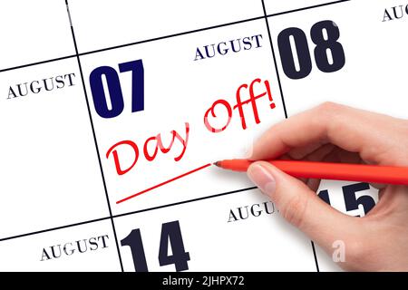 7th day of August. Hand writing text DAY OFF and drawing a line on calendar date 7 August. Vacation planning concept. Summer month, day of the year co Stock Photo