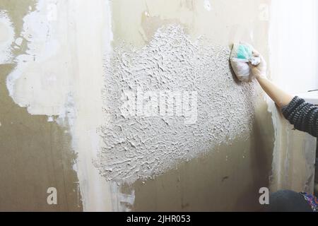 applying structural plaster to drywall, repairing the interior yourself Stock Photo