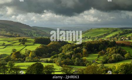 Scenic rural Wharfedale landscape (wide green valley, high uplands, sunlight on fields, cloudy sky & sun after rain) - North Yorkshire, England, UK. Stock Photo