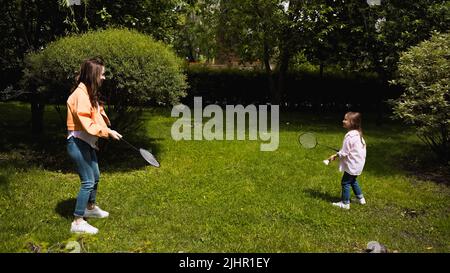 mother and daughter playing badminton in green park Stock Photo