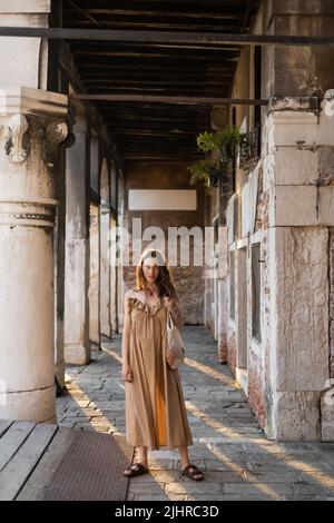 Pregnant woman holding string bag near old building in Venice Stock Photo
