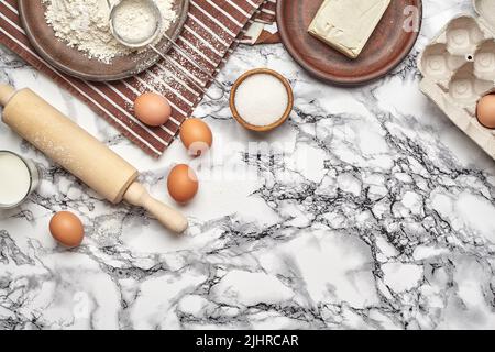 Close-up shot. Top view of a baking ingredients and kitchenware on the marble table background. Stock Photo
