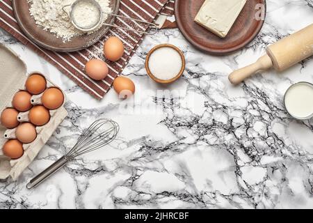 Close-up shot. Top view of a baking ingredients and kitchenware on the marble table background. Stock Photo