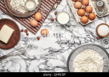 Close-up shot. Top view of a baking ingredients and kitchenware on the marble table background. Stock Photo