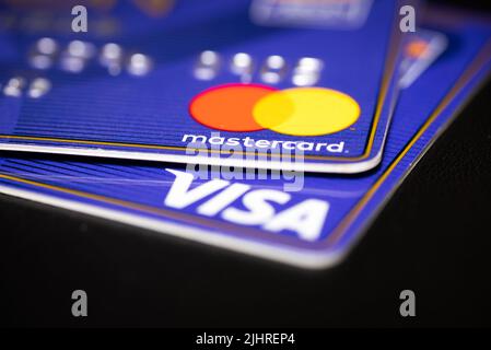Visa and Mastercard credit cards close up shot on a black surface table Stock Photo