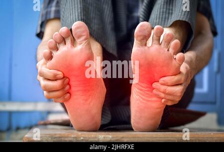 Tingling and burning sensation in feet of Asian old man with diabetes. Foot pain. Sensory neuropathy problems. Foot nerves problems. Plantar fasciitis Stock Photo