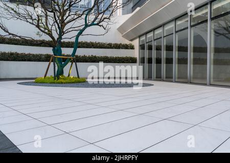 A top view of white and gray empty ground floor in front of modern office building exterior Stock Photo