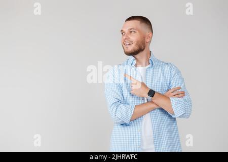 Young handsome bearded man pointing to the side Stock Photo