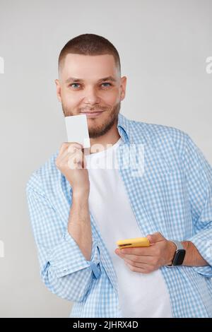 handsome man with smartphone and credit card Stock Photo