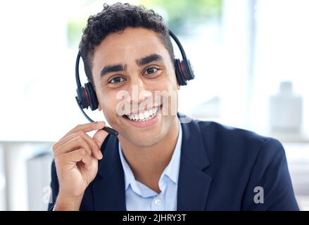 Portrait of one happy smiling mixed race call centre telemarketing agent talking on headset in office. Face of confident and friendly hispanic Stock Photo