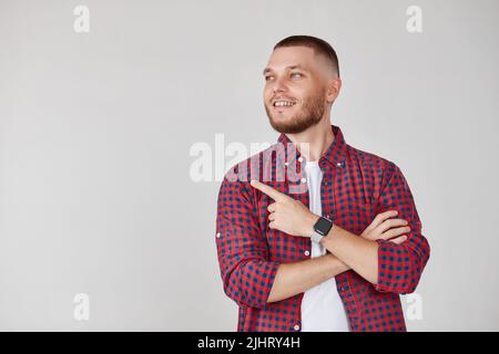 Young handsome bearded man pointing to the side Stock Photo