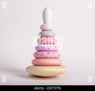 Wooden arranged pyramid. Learning toy for toddler in tender pink, pastel colors. High quality photo Stock Photo