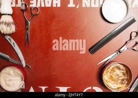 Scissors hairbrush and wax frame on red free space Stock Photo
