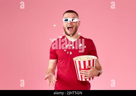 young man in 3d glasses throwing up and eating popcorn Stock Photo