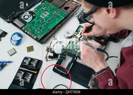 Repairman soldering electronic components on cpu Stock Photo