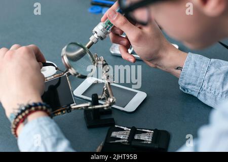 Soldering broken smartphone in repair shop closeup Stock Photo