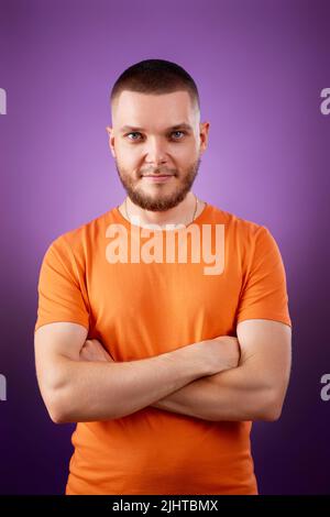 smiling young guy posing with crossed arms Stock Photo