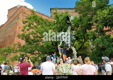 KRAKOW, POLAND - AUGUST 2021: The Wawel Dragon of the Wawel Royal Castle. Tourists exploring the Wawel Hill, the most historically and culturally impo Stock Photo