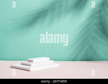 Abstract podium pedestal from white marble, blue menthol empty background deep shadows from plant Stock Photo