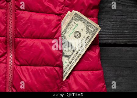 one dollar sticking out of the pocket of a red jacket, Ukrainian money, finance Stock Photo